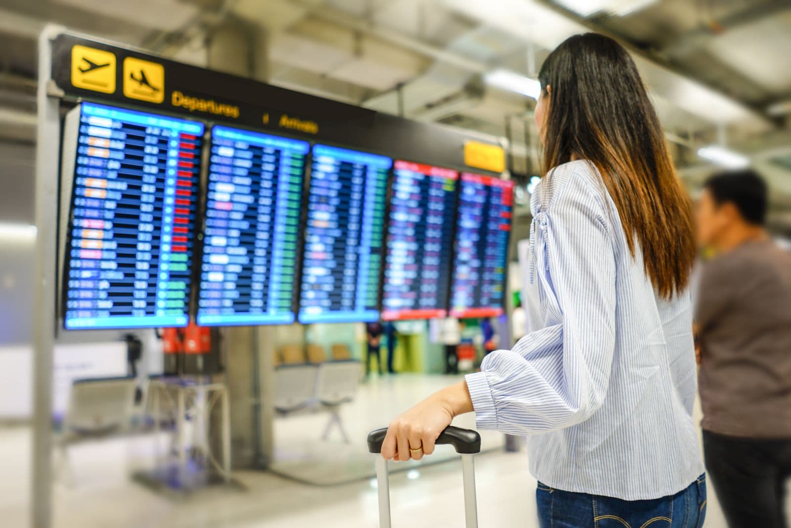 A traveller looks at the departures board at an airport