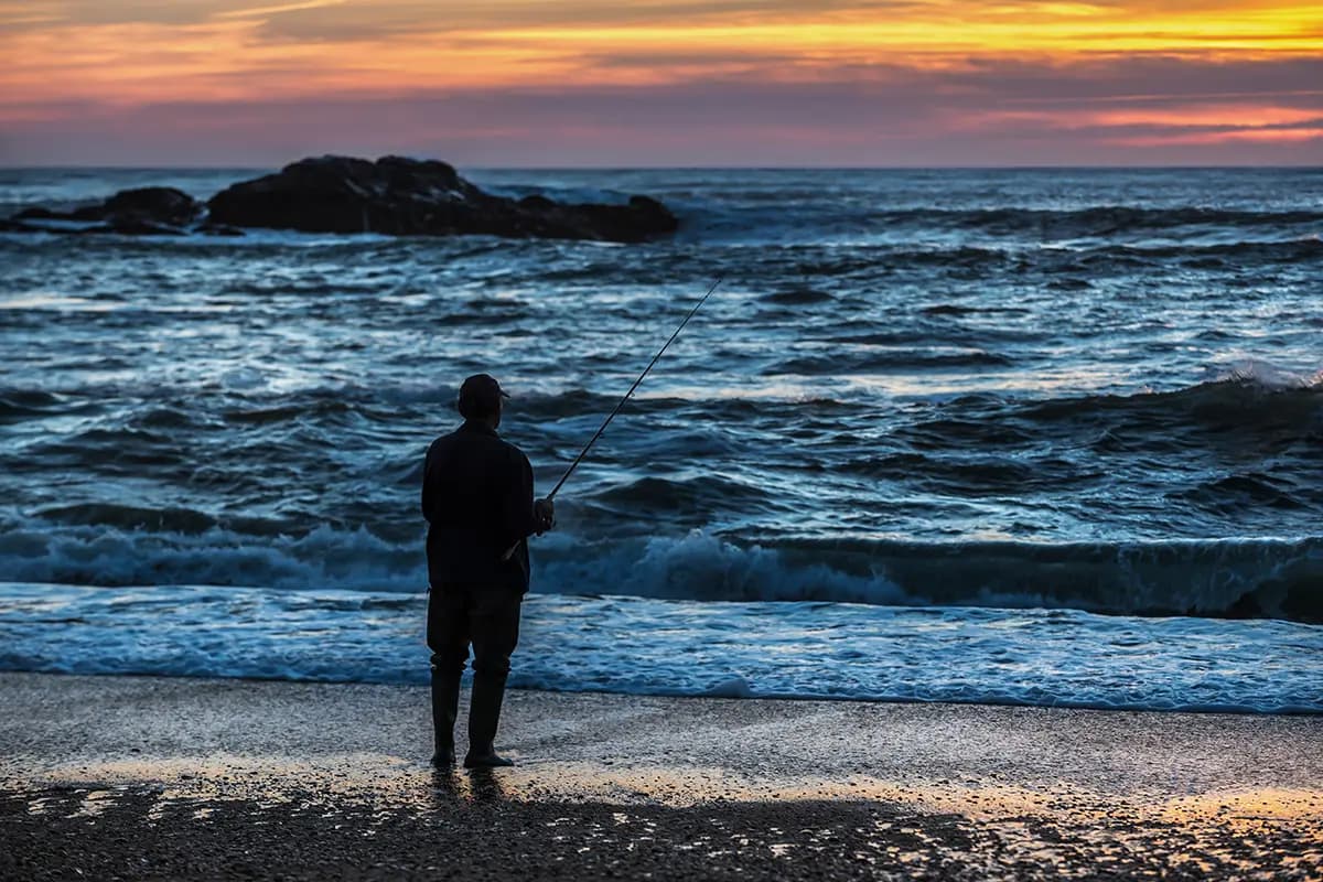 Man fishing in Foz do Douro in the late evening.
