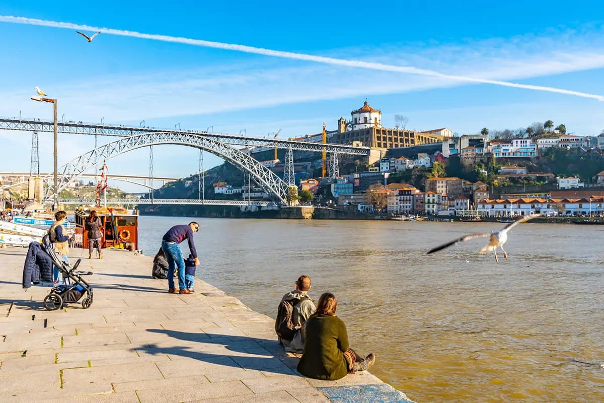 People sitting by the Ribeira, in Porto, enjoying a winter morning.