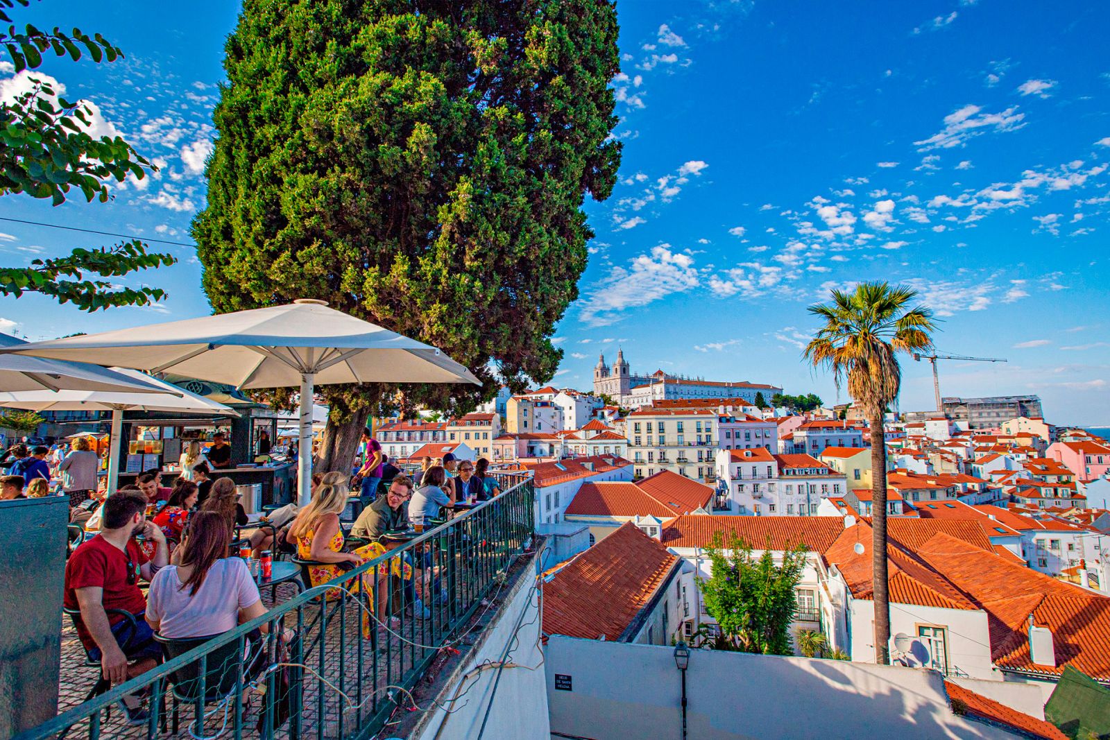 People enjoying summer day by café shop in Lisbon.